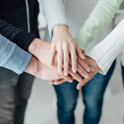 Young people stacking hands